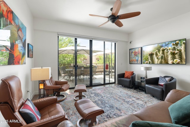 living area with baseboards and a ceiling fan