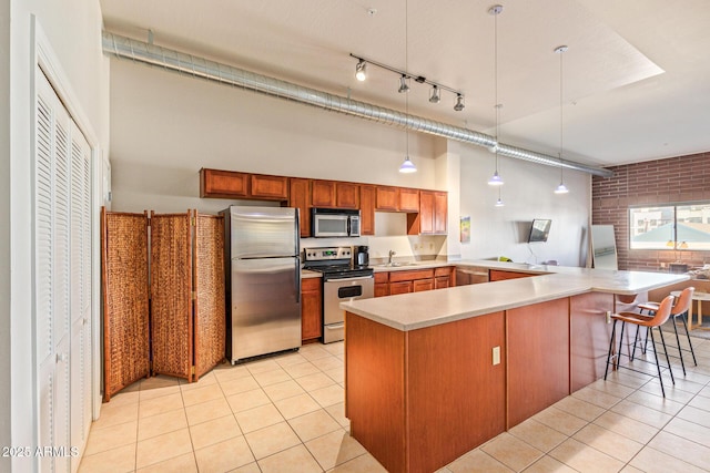 424 S 2nd St Unit 203, Phoenix, AZ 85004 - kitchen with stainless steel appliances, a peninsula, light tile patterned floors, light countertops, and pendant lighting