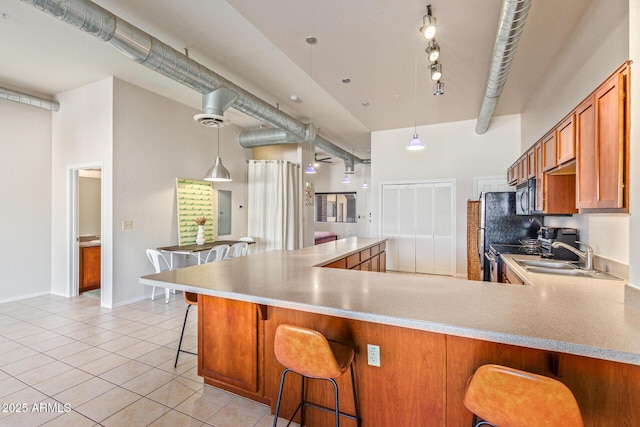 424 S 2nd St Unit 203, Phoenix, AZ 85004 - kitchen with appliances with stainless steel finishes, brown cabinets, light tile patterned flooring, a high ceiling, and light countertops