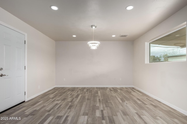 spare room with recessed lighting, visible vents, baseboards, and wood finished floors