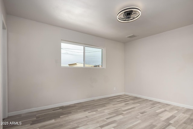 empty room featuring visible vents, baseboards, and light wood-style floors