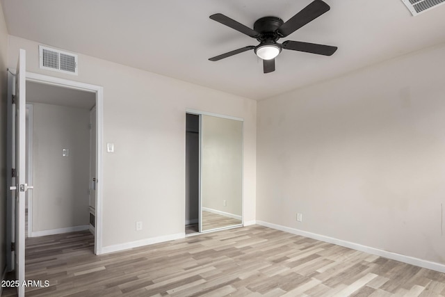 unfurnished bedroom with a closet, baseboards, visible vents, and light wood finished floors