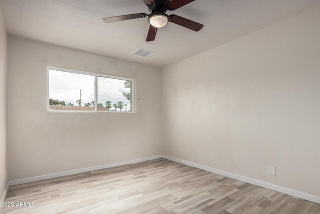 spare room featuring light wood-type flooring, visible vents, baseboards, and a ceiling fan