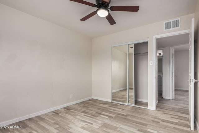 unfurnished bedroom with visible vents, baseboards, a closet, and light wood-style flooring