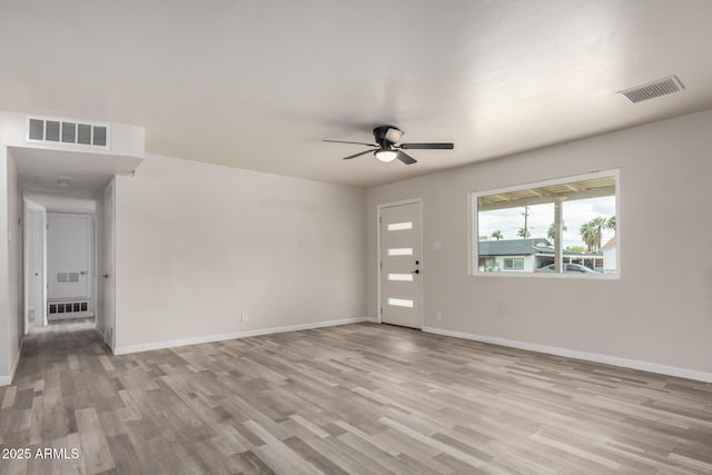 interior space featuring visible vents, wood finished floors, baseboards, and ceiling fan