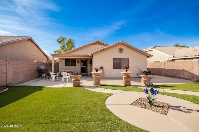 rear view of house featuring a yard and a patio