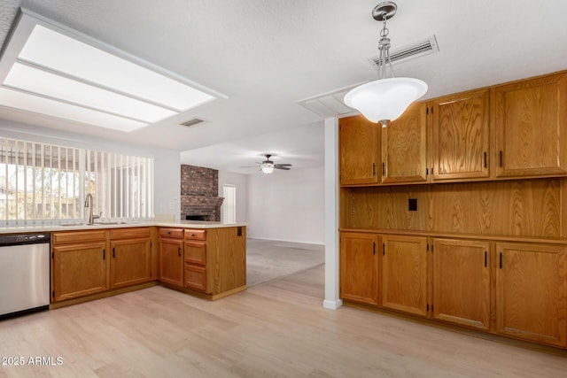 kitchen with dishwasher, ceiling fan, sink, light hardwood / wood-style flooring, and decorative light fixtures