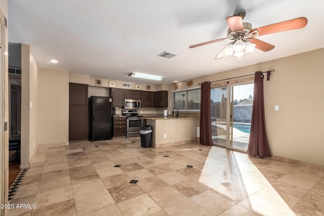 kitchen featuring a breakfast bar, sink, dark brown cabinets, appliances with stainless steel finishes, and ceiling fan