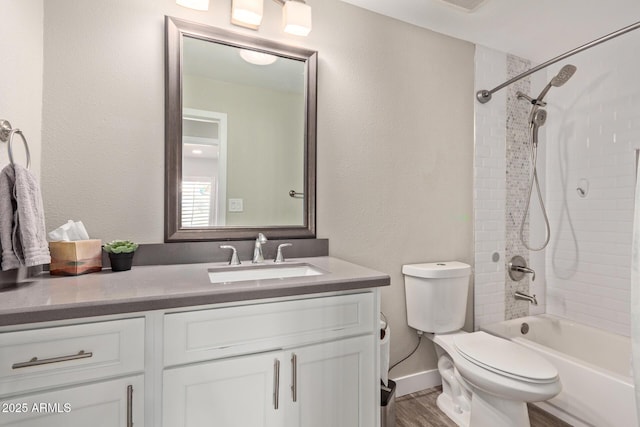 full bathroom with toilet, hardwood / wood-style flooring, tiled shower / bath, and vanity