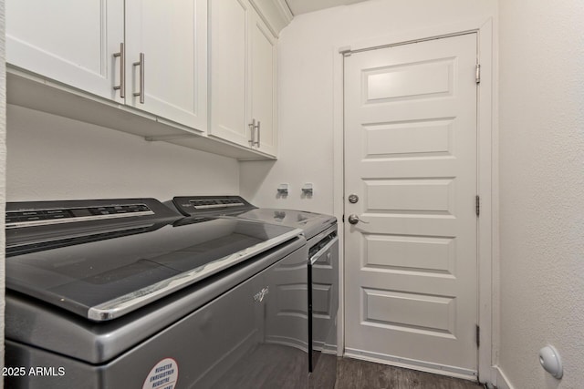 clothes washing area featuring separate washer and dryer, cabinets, and dark hardwood / wood-style floors