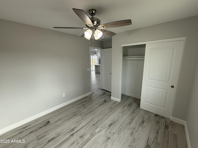 unfurnished bedroom featuring ceiling fan, light hardwood / wood-style floors, and a closet