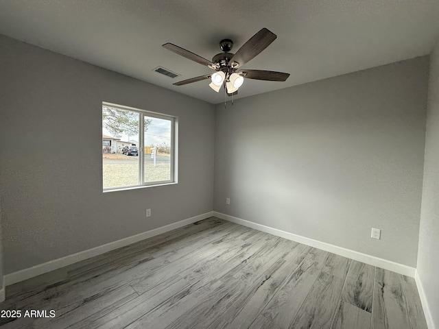 empty room with ceiling fan and light hardwood / wood-style floors