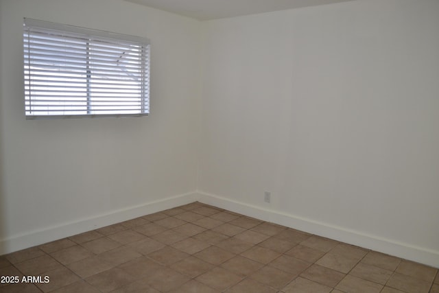 unfurnished room featuring baseboards