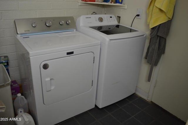 washroom featuring laundry area, dark tile patterned flooring, and independent washer and dryer