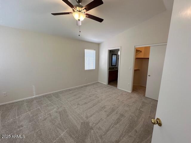 21192 N 80th Ln, Peoria, AZ 85382 - unfurnished bedroom featuring a spacious closet, vaulted ceiling, carpet floors, baseboards, and ceiling fan