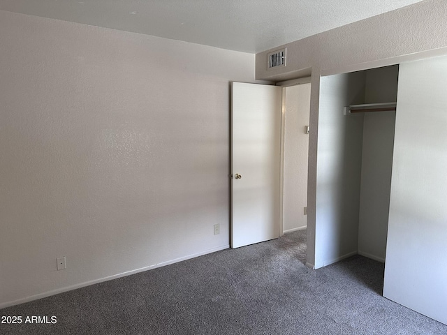 unfurnished bedroom featuring carpet floors, visible vents, and a closet