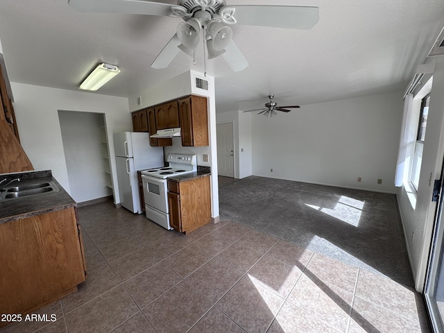 kitchen featuring white appliances, a sink, visible vents, dark carpet, and dark countertops