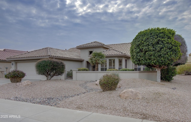 mediterranean / spanish-style home with a garage