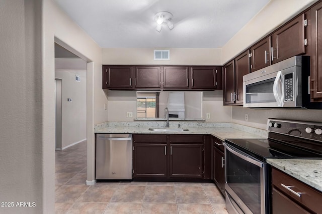 kitchen featuring stainless steel appliances, a sink, visible vents, and dark brown cabinetry