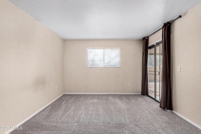 unfurnished room featuring carpet floors and baseboards