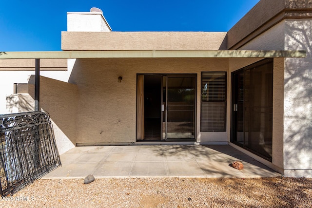 doorway to property featuring a patio area, fence, and stucco siding