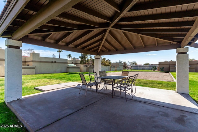 view of patio featuring outdoor dining space, fence, and a gazebo