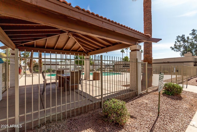 view of patio / terrace with fence, a fenced in pool, and a gazebo