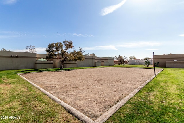 view of community with volleyball court, a yard, and fence