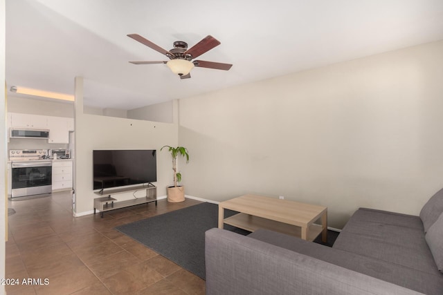 living room with dark tile patterned flooring and ceiling fan