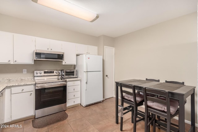 kitchen featuring white cabinets, light tile patterned floors, and appliances with stainless steel finishes