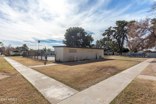 exterior space featuring a front lawn and a pool