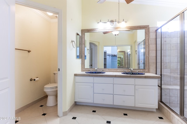 bathroom with crown molding, vanity, toilet, and a shower with door