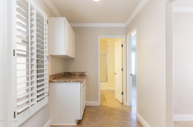 corridor with baseboards, crown molding, and light tile patterned floors
