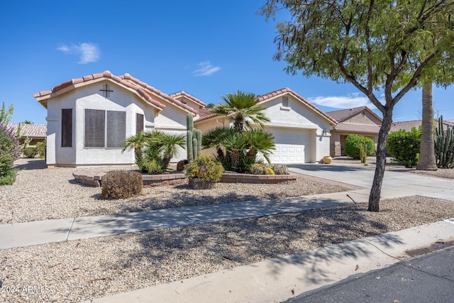 view of front of home with stucco siding, driveway, a garage, and a tiled roof