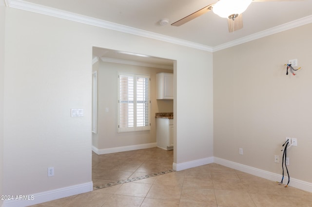 tiled empty room with ceiling fan and ornamental molding