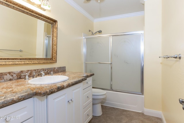 full bath featuring tile patterned flooring, vanity, toilet, ornamental molding, and combined bath / shower with glass door