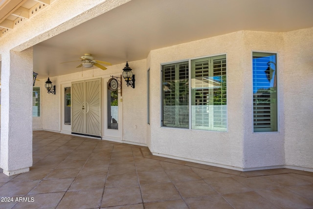doorway to property featuring stucco siding, a ceiling fan, and a patio area