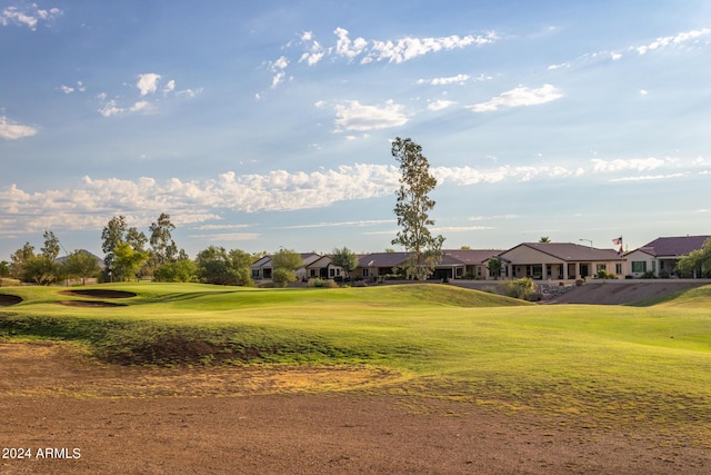 view of property's community featuring golf course view, a yard, and a residential view