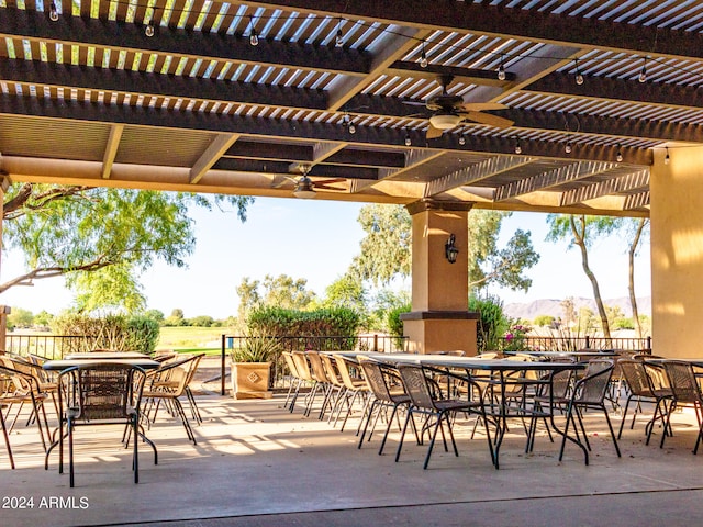 view of patio featuring a pergola, ceiling fan, and a mountain view