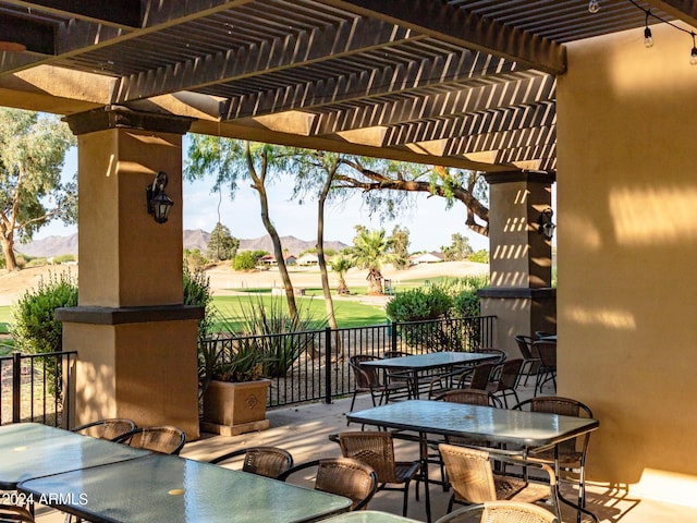 view of patio with a pergola, outdoor dining area, and a mountain view