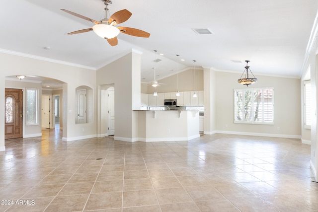 unfurnished living room with crown molding, vaulted ceiling, ceiling fan, and light tile patterned floors