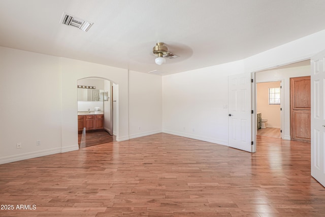 238 W Myrna Ln, Tempe, AZ 85284 - spare room featuring a ceiling fan, arched walkways, and light wood-style floors