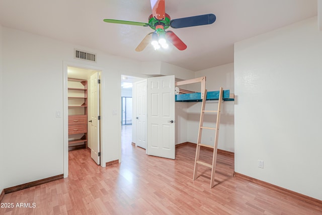 238 W Myrna Ln, Tempe, AZ 85284 - unfurnished bedroom featuring light wood-type flooring, a closet, a spacious closet, and a ceiling fan