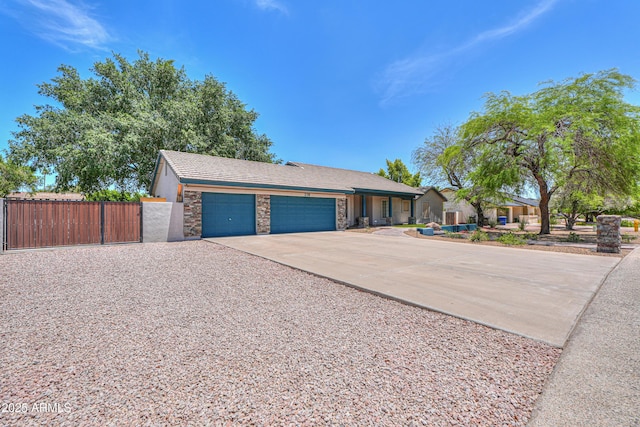 238 W Myrna Ln, Tempe, AZ 85284 - view of front of house with concrete driveway, an attached garage, a gate, and stone siding