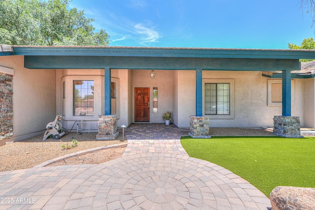 238 W Myrna Ln, Tempe, AZ 85284 - view of exterior entry featuring stucco siding, a porch, and a yard
