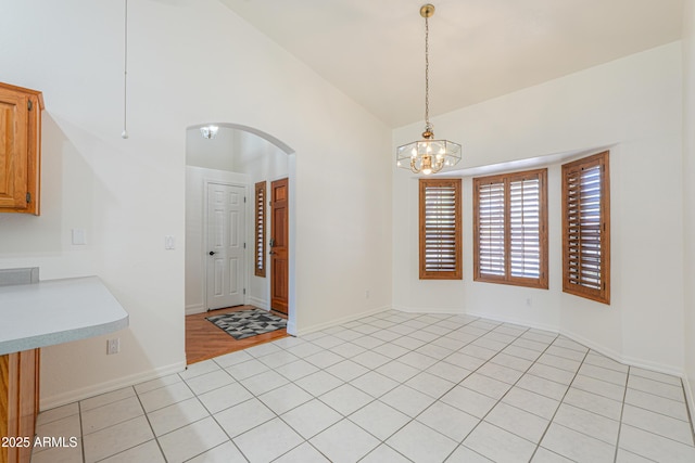 238 W Myrna Ln, Tempe, AZ 85284 - unfurnished dining area with arched walkways, a chandelier, light tile patterned flooring, and high vaulted ceiling