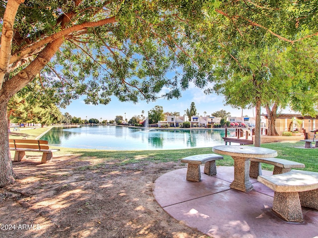 view of pool with a water view and a yard