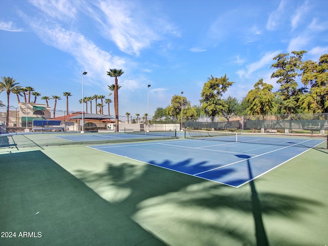 view of tennis court featuring fence and community basketball court