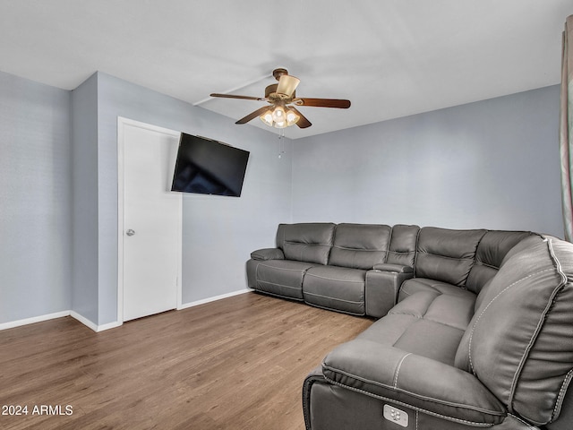 living area with baseboards, ceiling fan, and wood finished floors