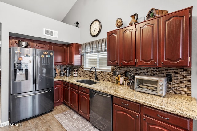 kitchen with sink, light hardwood / wood-style flooring, stainless steel appliances, light stone countertops, and vaulted ceiling